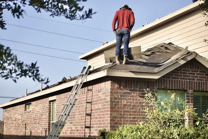 Professional roofer working on a residential roof in West Amityville